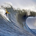 Surfer hitting a huge wave